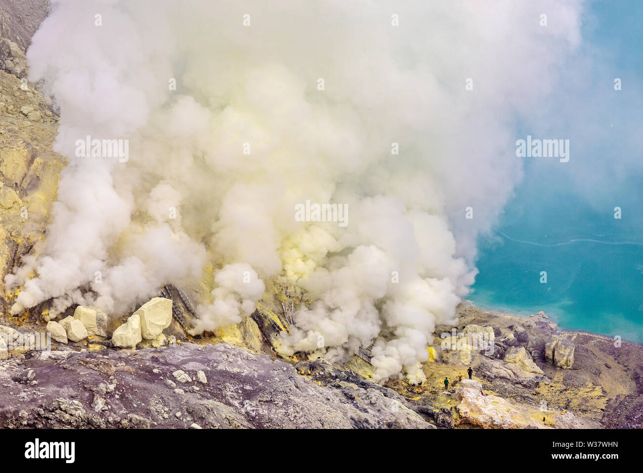 Il cratere di un vulcano con una verde acido solforico lago vulcanico e vulcaniche di fumo. Vista del Vulcano fumatori Kawah Ijen in Indonesia Foto Stock