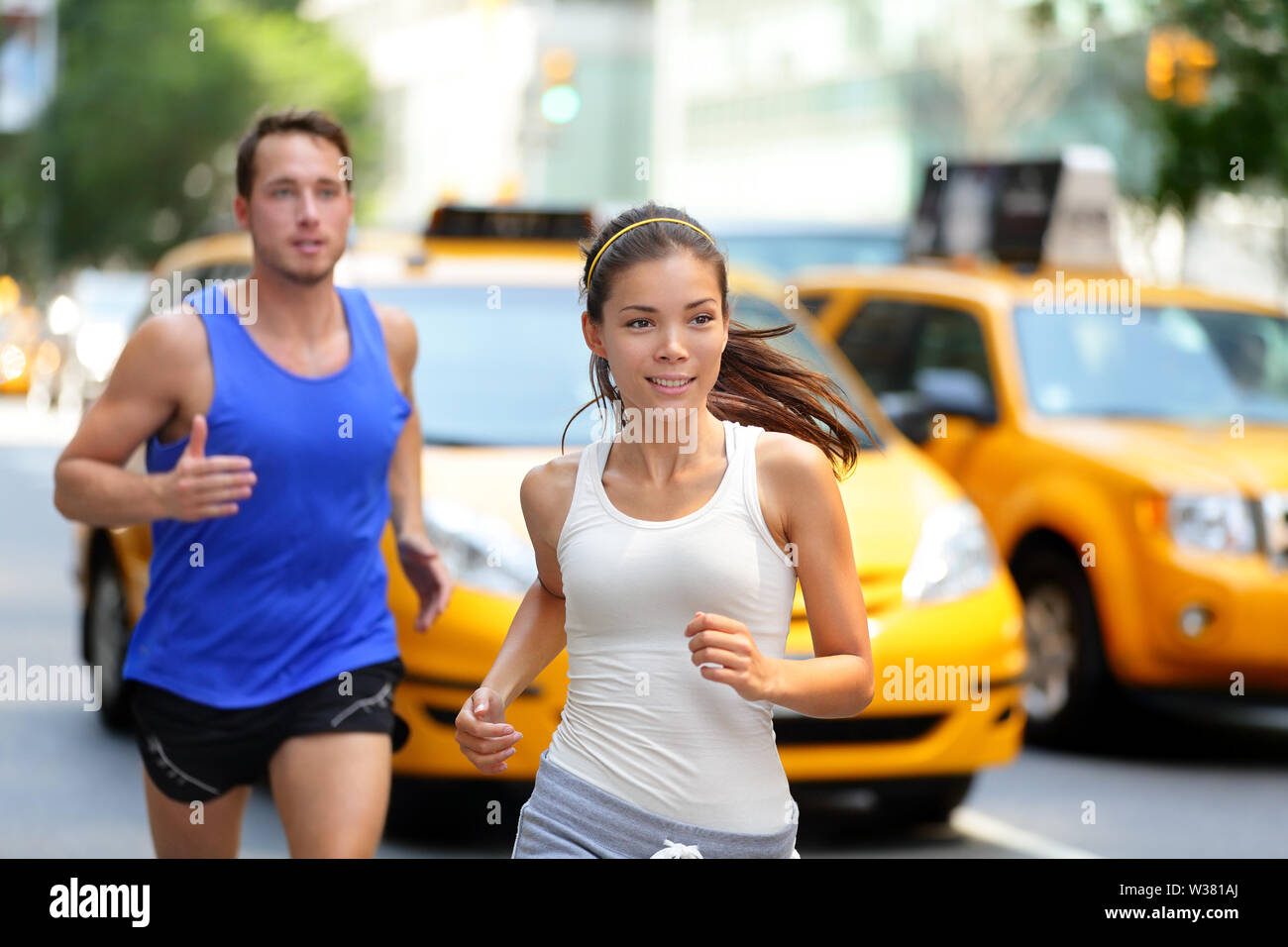 Coppia attivi in esecuzione sulla famosa via dello shopping Fifth Avenue a Manhattan, New York New York, Stati Uniti d'America. Esercizio lifestyle Ritratto di giovane donna asiatica runner e caucasici pareggiatore maschio. Foto Stock