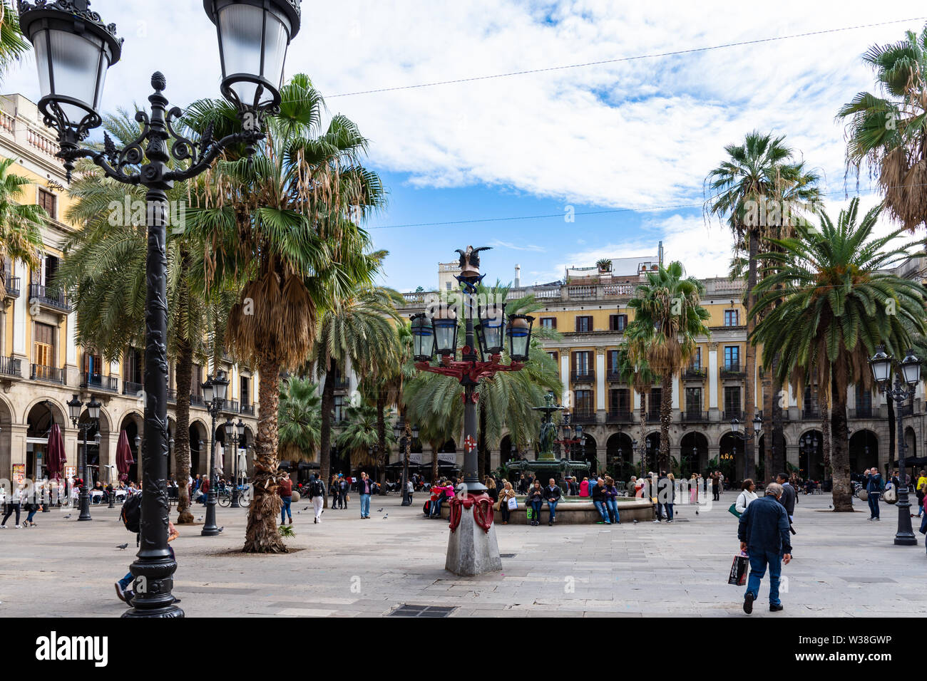 Barcellona, Spagna - 02 Novembre 2018: Placa Reial, ombreggiata da palme e raffreddato da una fontana. Lampada colorata posti noti come Gaudì prima opera del CEN Foto Stock