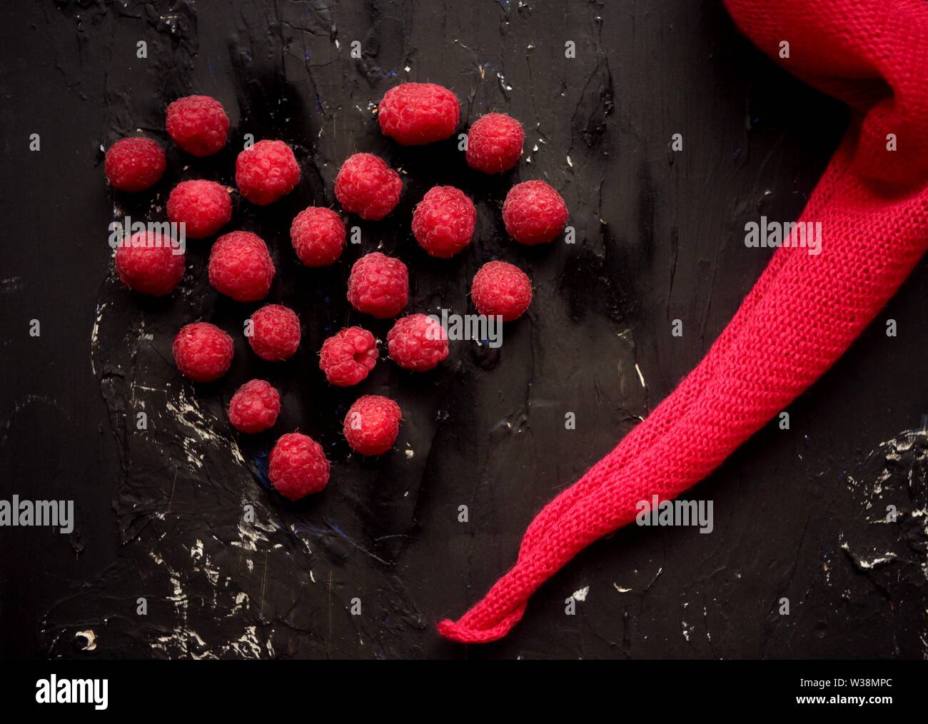 Set di lamponi freschi isolati su sfondo nero. La fotografia macro. Foto Stock