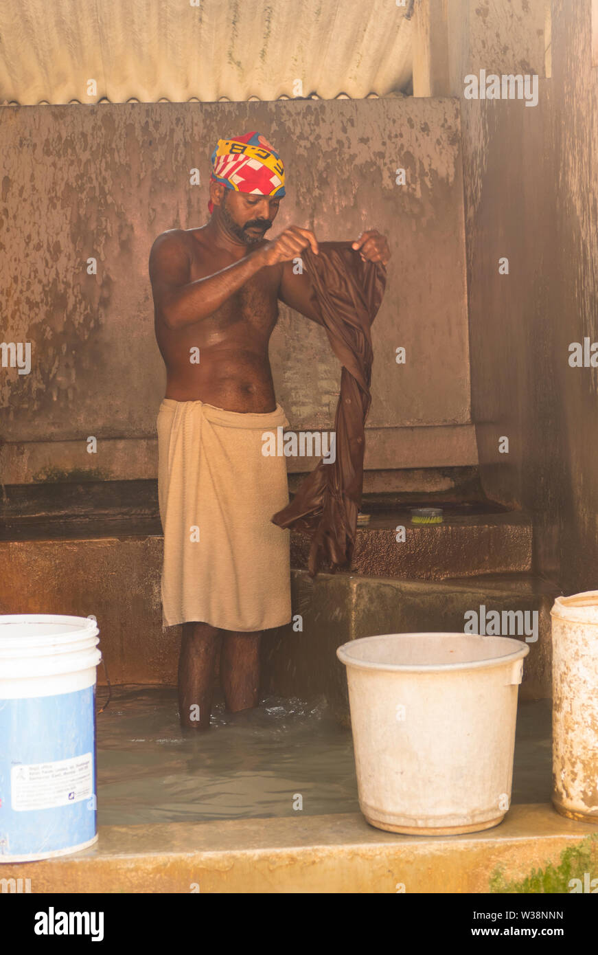 Indiana tradizionale lavoratore uomo a lavare i panni nel tradizionale locale lavanderia Business in Kochi in India meridionale. Foto Stock