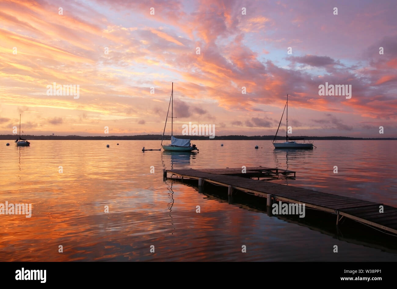 Incredibile serata estiva paesaggio con gruppo di drifting yachts su un lago Mendota durante il tramonto spettacolare. Il cielo luminoso riflette nelle acque del lago. Mad Foto Stock