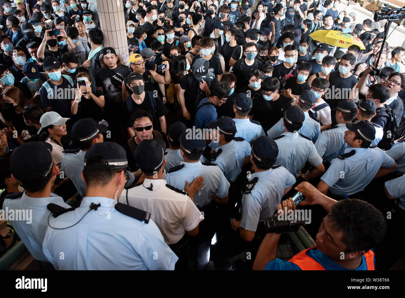 Gli ufficiali di polizia bloccare i manifestanti' modo durante la dimostrazione.Migliaia di manifestanti sono scesi in strada del Sheung Shui nel quartiere nord di Hong Kong in un anti-commercio parallelo di marzo. Alcuni manifestanti si scontrano con la polizia dopo il mese di marzo. Numero di manifestanti sono riportati per essere feriti. Foto Stock