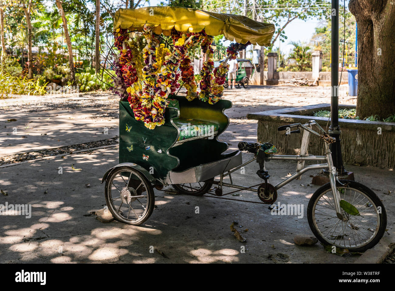Puerto Princesa, PALAWAN FILIPPINE - Marzo 3, 2019: primo piano della non-triciclo motorizzato taxi decorato con fiore ilo sul lato di Rizal Park. Ombra Foto Stock