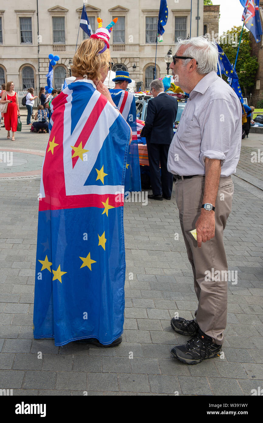 Westminster, Londra, Regno Unito. Il 26 giugno, 2019. Un Brexit restano i diruttori indossa un Unione Jack e bandiera UE come ella chat per un uomo al di fuori della Camera dei Comuni. Credito: Maureen McLean/Alamy Foto Stock