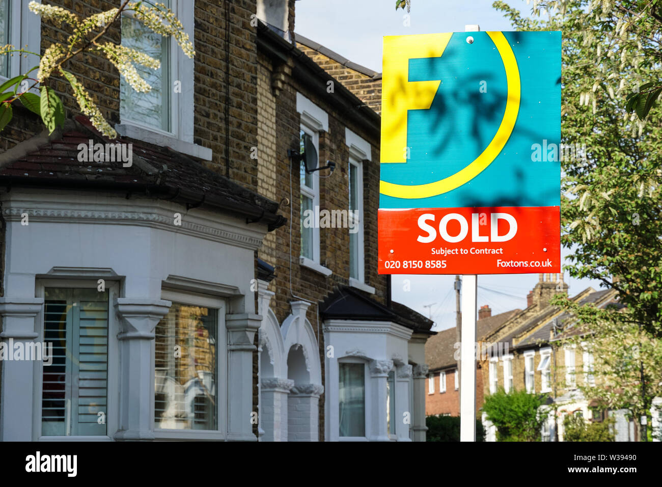 Foxtons immobili venduti segno fuori case a schiera a Londra Inghilterra Regno Unito Regno Unito Foto Stock