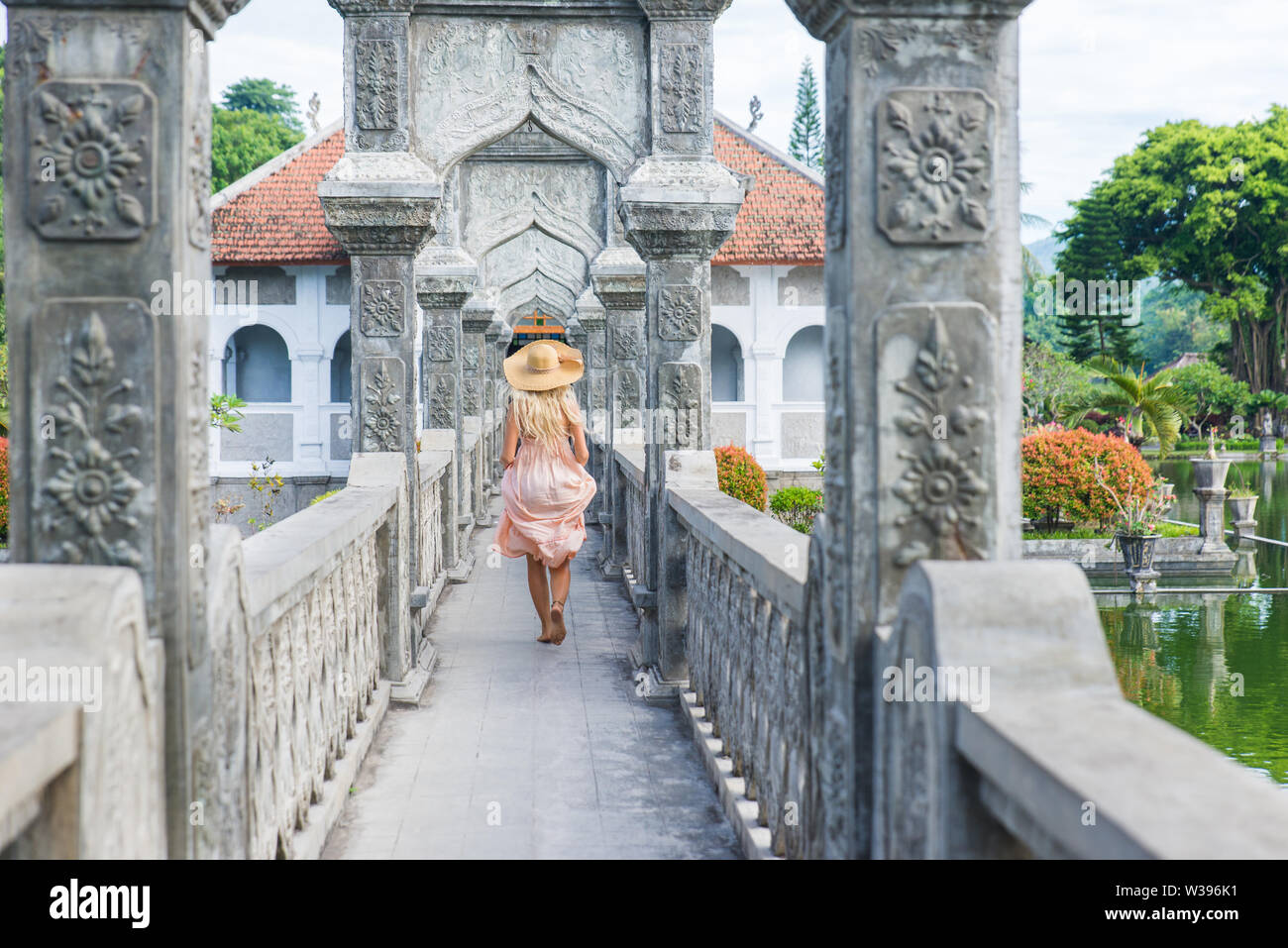 Giovane bella donna di Taman Ujung acqua palace, isola di Bali, Indonesia - Travel blogger esplorare l'acqua Palace a Bali Foto Stock