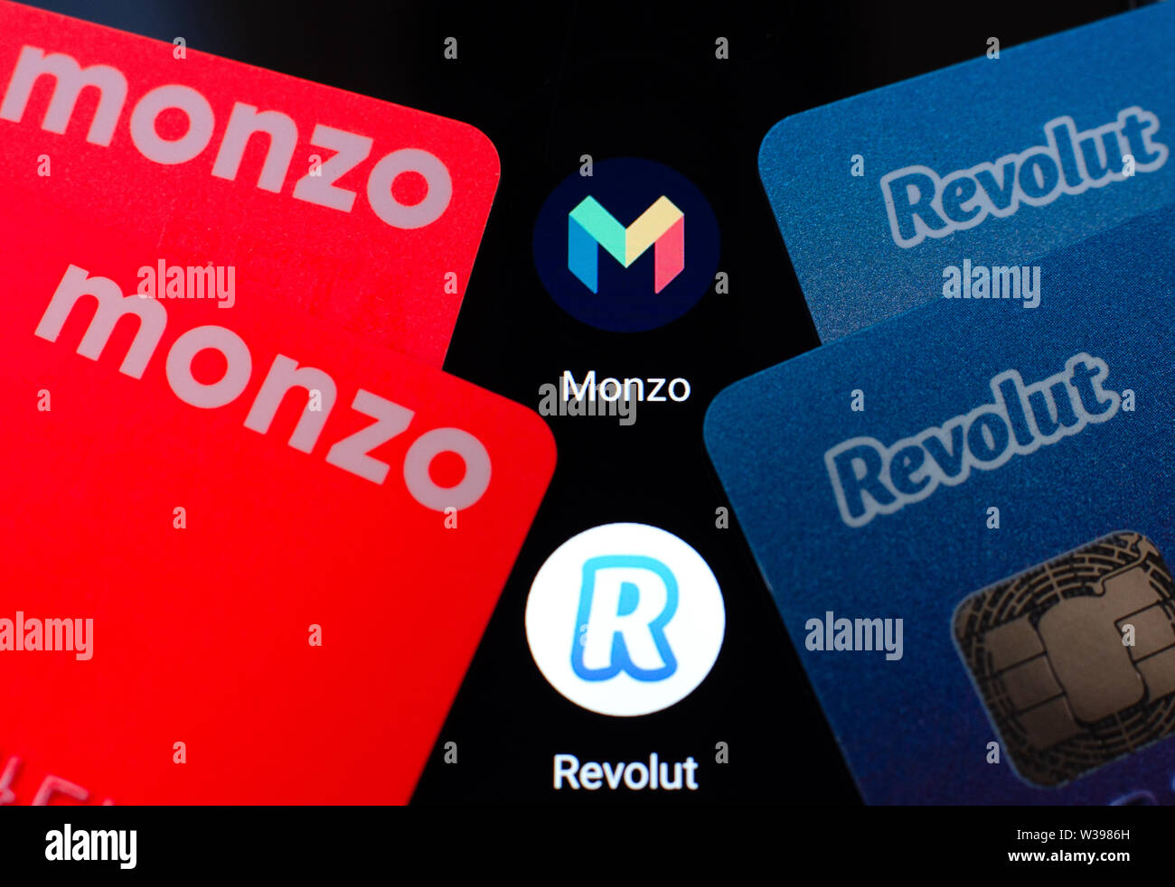 Foto macro di Monzo e Revolut carte bancarie sullo schermo dello smartphone accanto alle loro applicazioni. Foto concettuale per evidenziare la concorrenza. Foto Stock