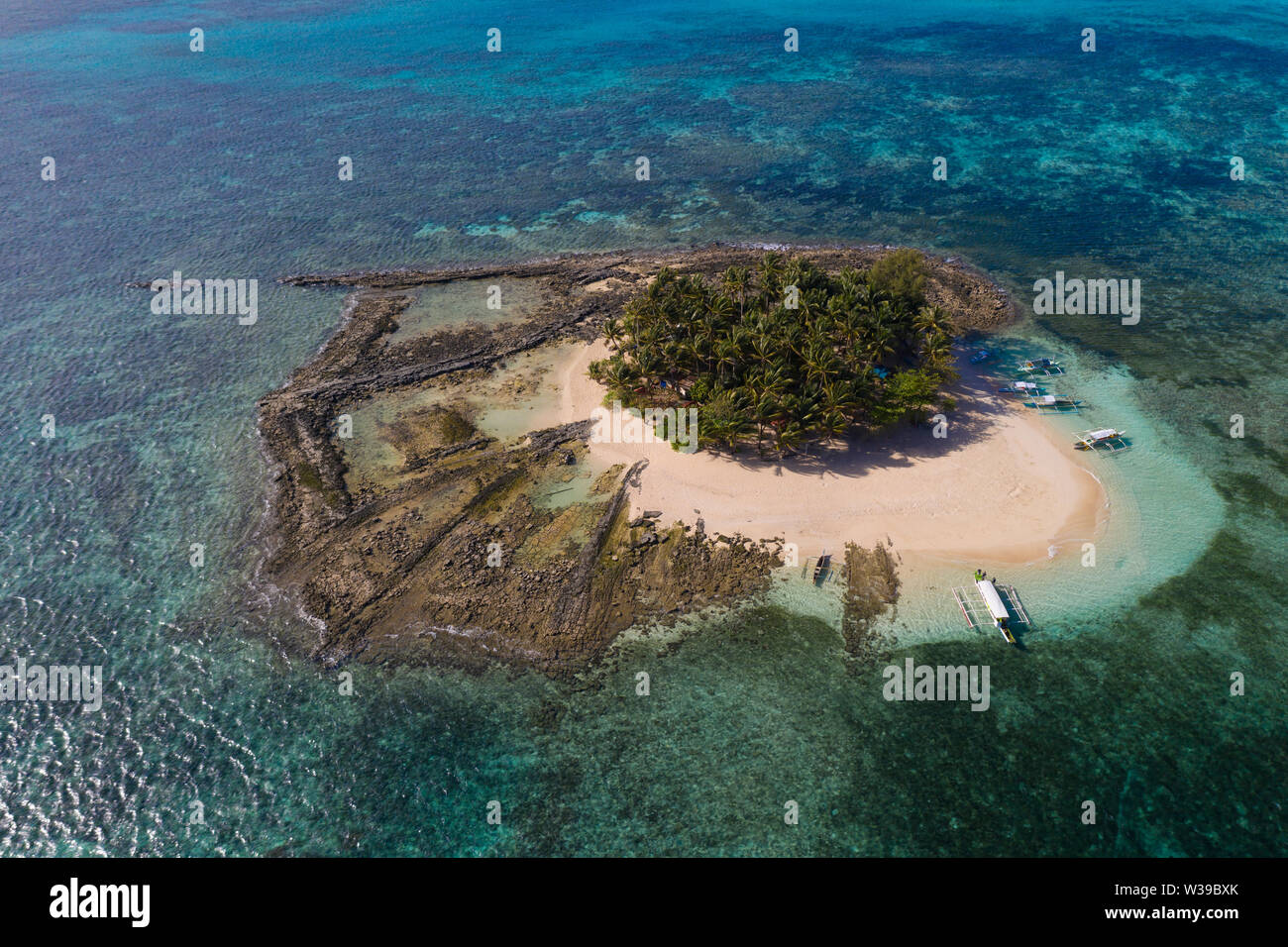 Guyam Isola, Siargao, Filippine - spiaggia tropicale con acqua blu e palme Foto Stock