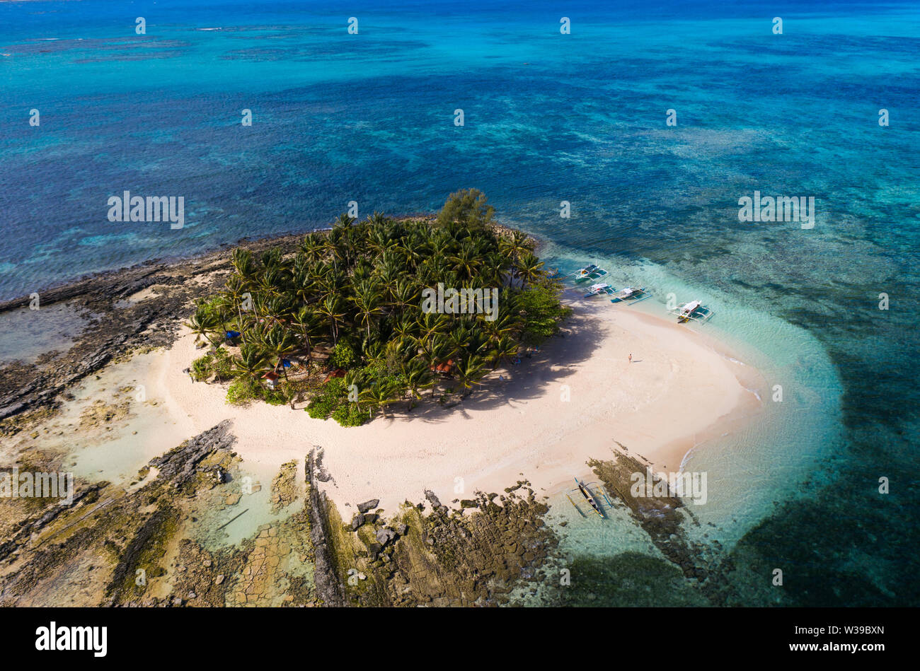 Guyam Isola, Siargao, Filippine - spiaggia tropicale con acqua blu e palme Foto Stock