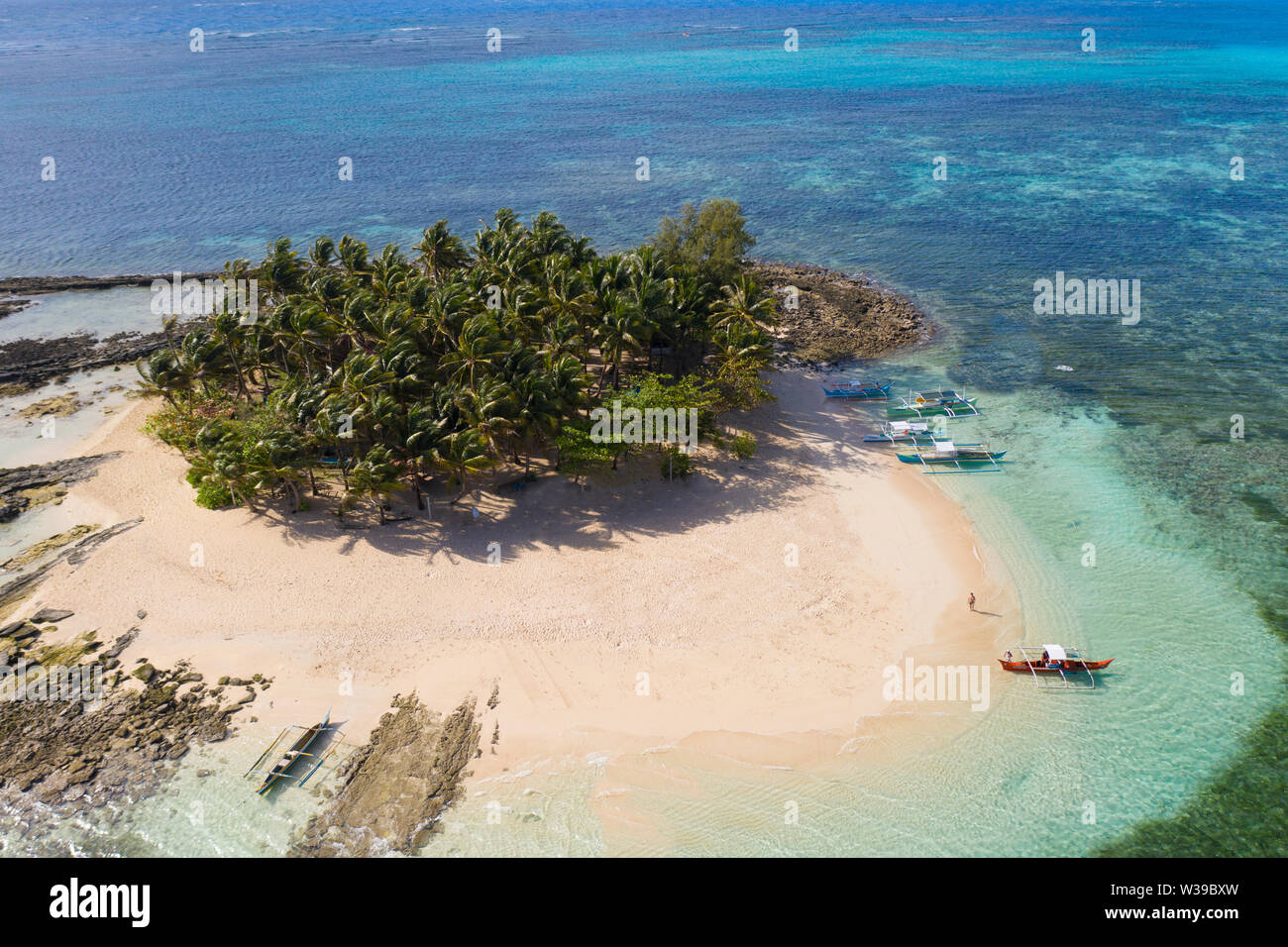 Guyam Isola, Siargao, Filippine - spiaggia tropicale con acqua blu e palme Foto Stock