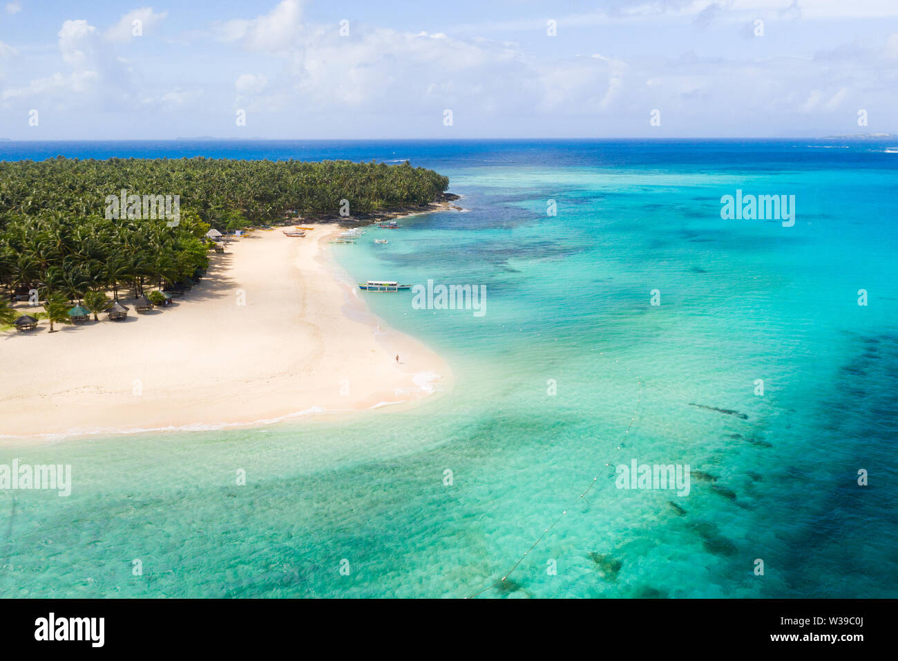Daku Isola, Siargao, Filippine - spiaggia tropicale con acqua blu e palme Foto Stock