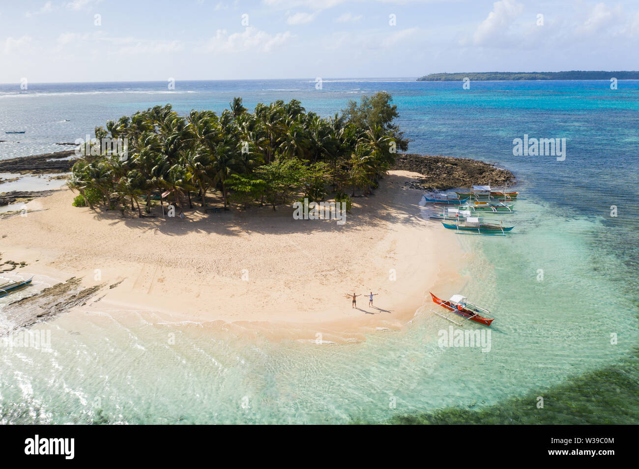 Guyam Isola, Siargao, Filippine - spiaggia tropicale con acqua blu e palme Foto Stock