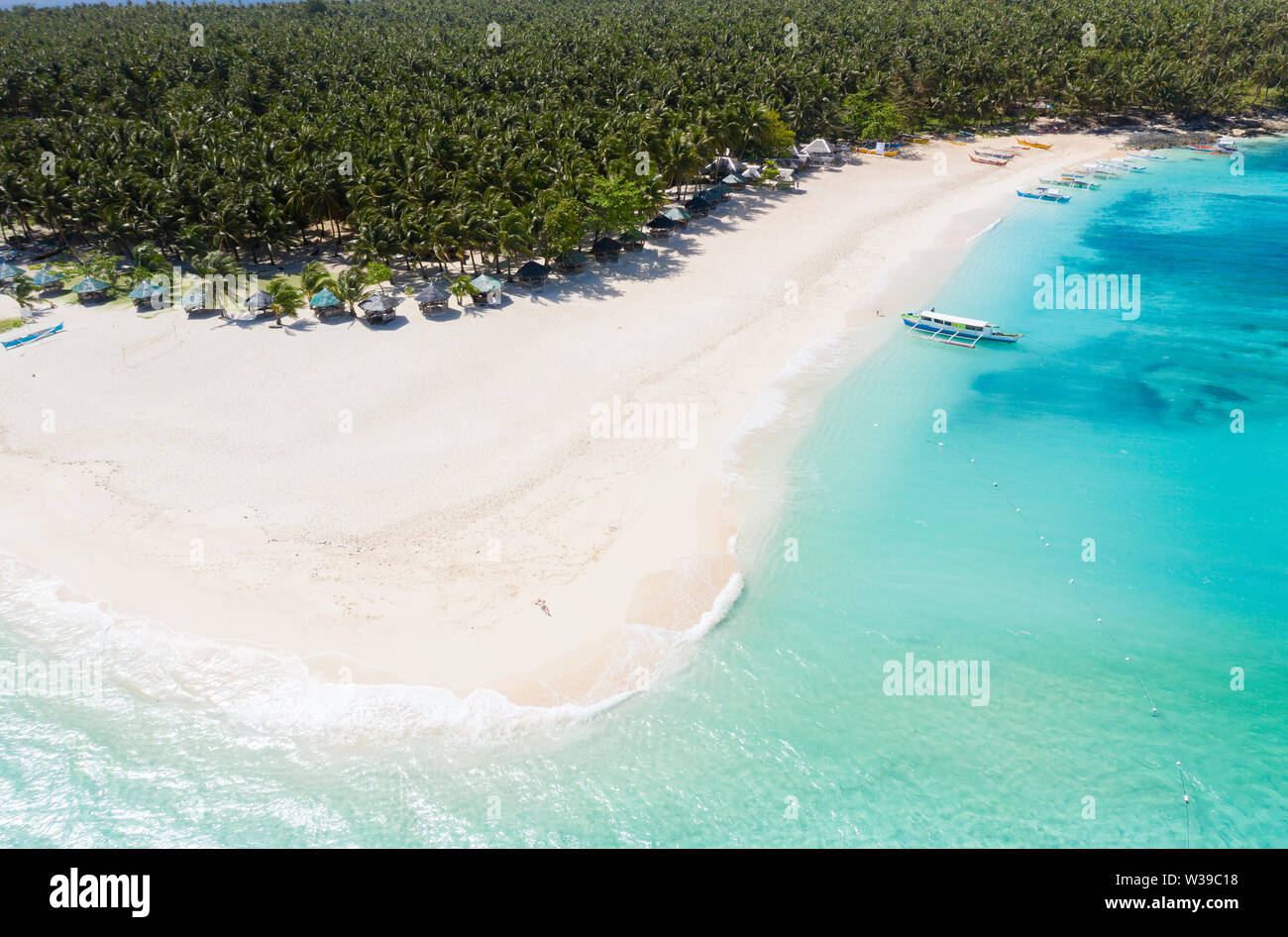 Daku Isola, Siargao, Filippine - spiaggia tropicale con acqua blu e palme Foto Stock