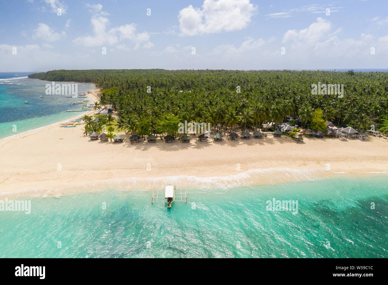 Daku Isola, Siargao, Filippine - spiaggia tropicale con acqua blu e palme Foto Stock