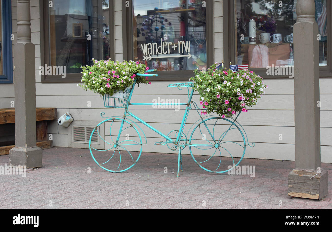 Una bicicletta in metallo supporto vegetale si siede di fronte a un negozio di articoli da regalo in Oregon centrale città di sorelle, Oregon. Foto Stock