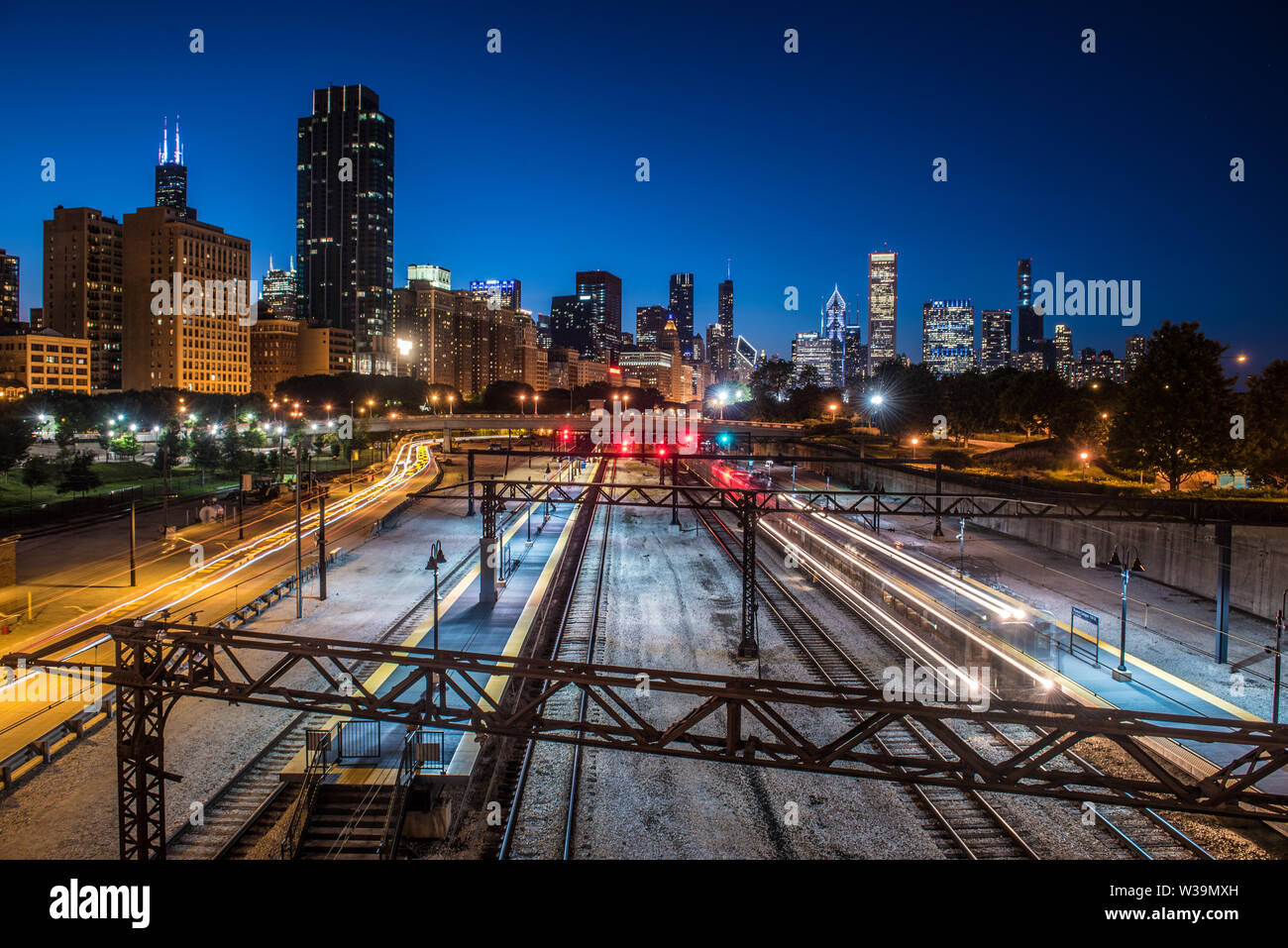 Vista della stazione centrale , treno el sentieri di luce e per il centro di Chicago skyline della città di blue ora Foto Stock