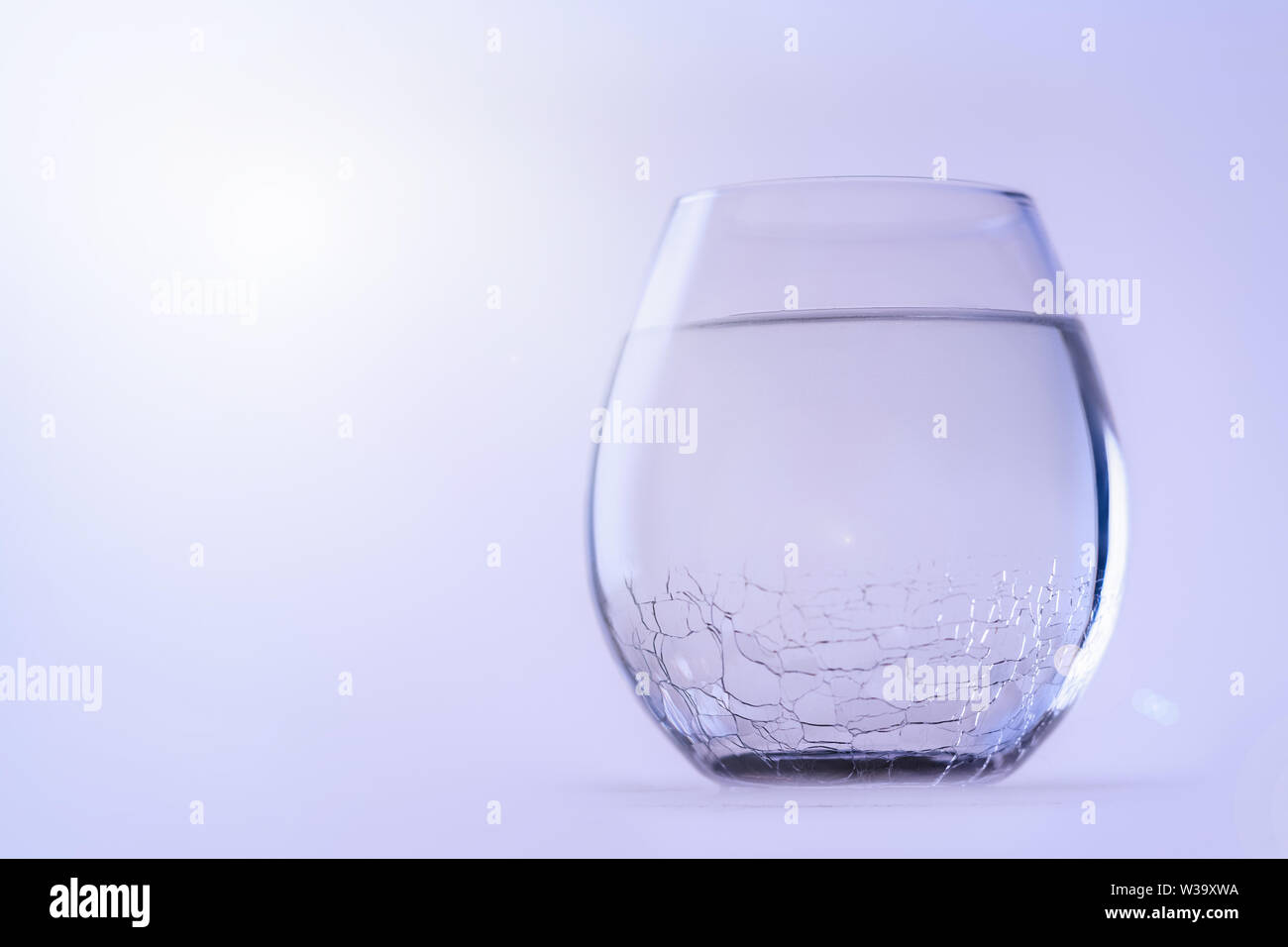 Un bicchiere di acqua fredda. Un vetro con un vetro rotto, copia dello spazio. Foto Stock