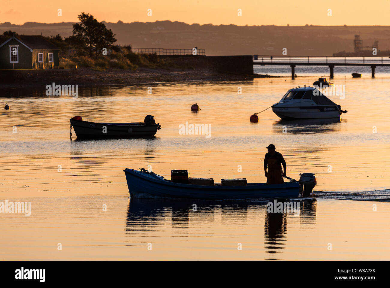 Crosshaven, Cork, Irlanda. 14 Luglio, 2019. Martin pescatore Fleming motori fuori per la sua barca da pesca di Winnie the Pooh all'alba in Crosshaven, Co. Il sughero che egli terrà fuori per le zone di pesca per controllare i suoi vasi per aragosta e granchio. Credito: David Creedon/Alamy Live News Foto Stock