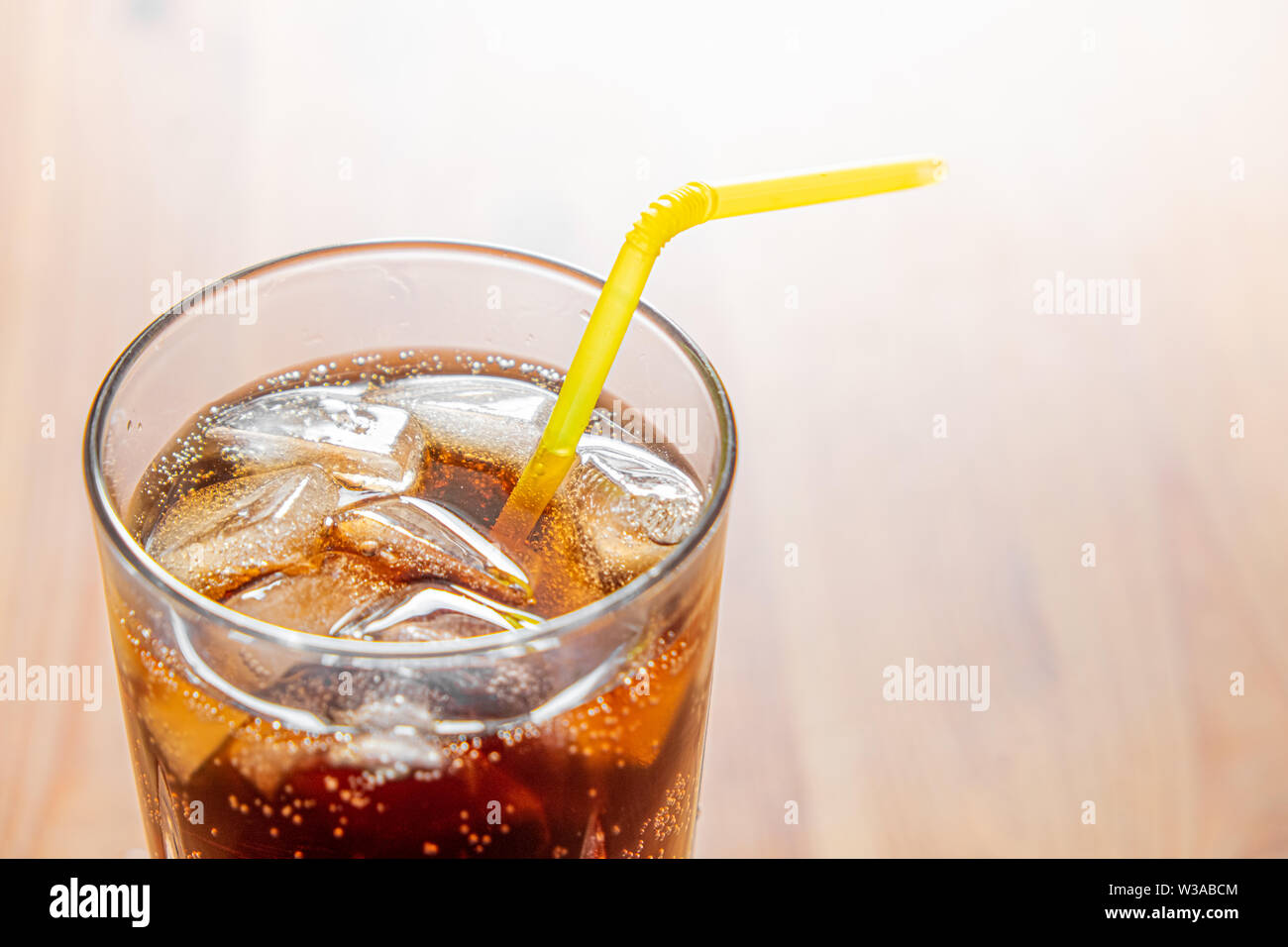 Icy bevanda fredda in un bicchiere e ravvicinata. Bicchiere di fresca bevanda frizzante con ghiaccio su una tavola di legno, shot dettagliati Foto Stock