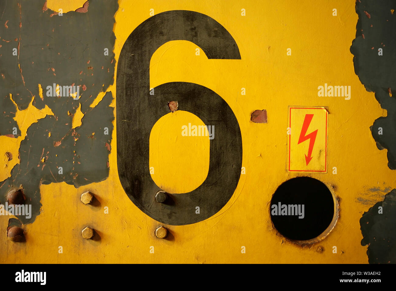 Il numero nero 6 su dipinte di un giallo superficie in acciaio. Foto Stock