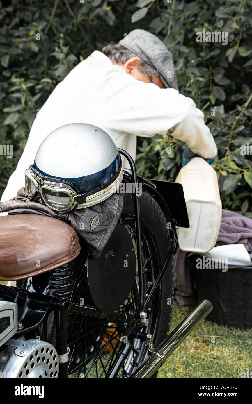 L'uomo mantenendo un 1928 Douglas SWS modello di velocità, classic motociclo a Oakamoor Hill Climb, 13 luglio 2019, Oakamoor, Staffordshire, Regno Unito Foto Stock