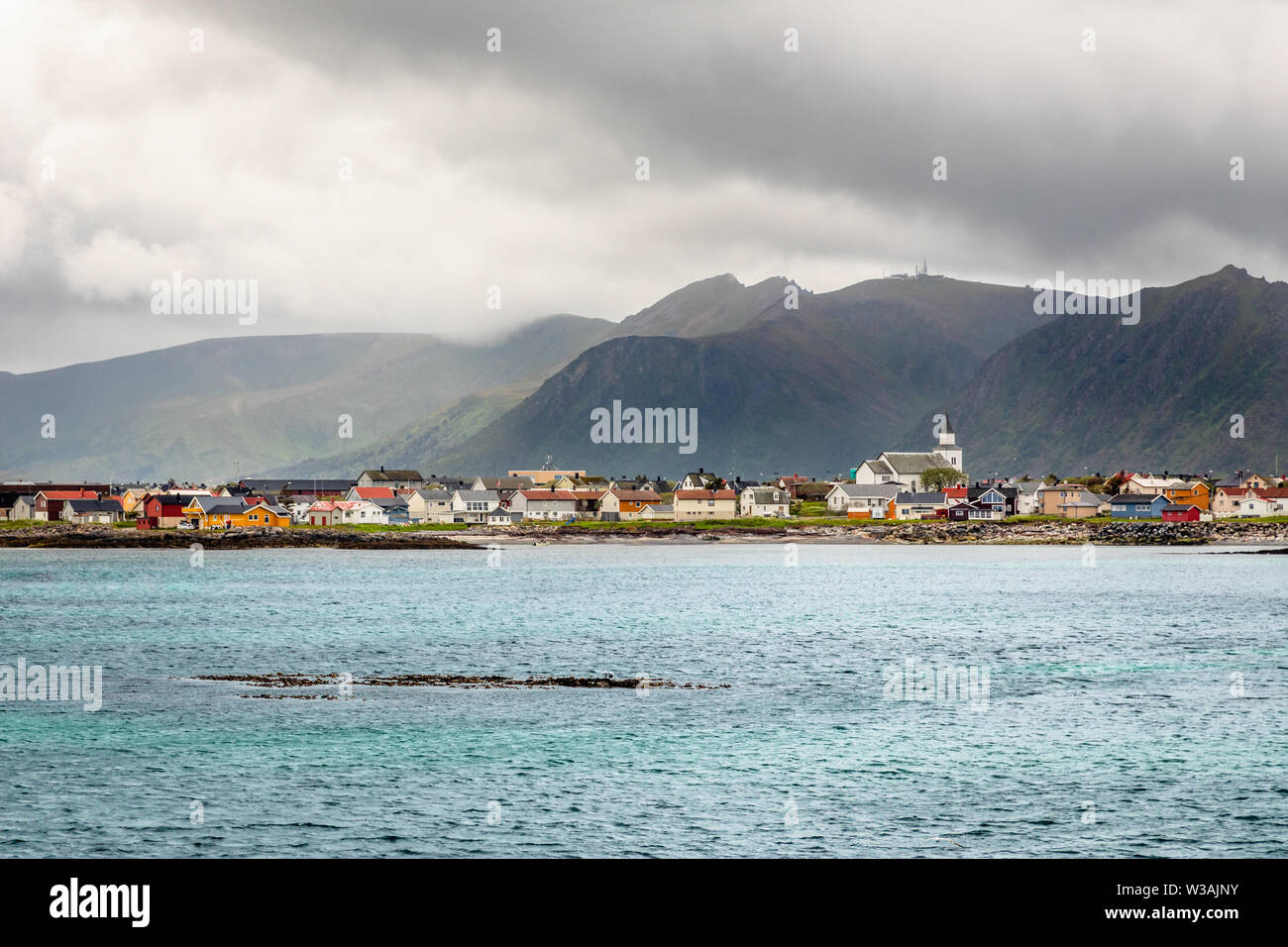 Villaggio Andenes panorama con più case e le montagne sullo sfondo, isole Lofoten Andoy comune, quartiere Vesteralen, Nordland coun Foto Stock