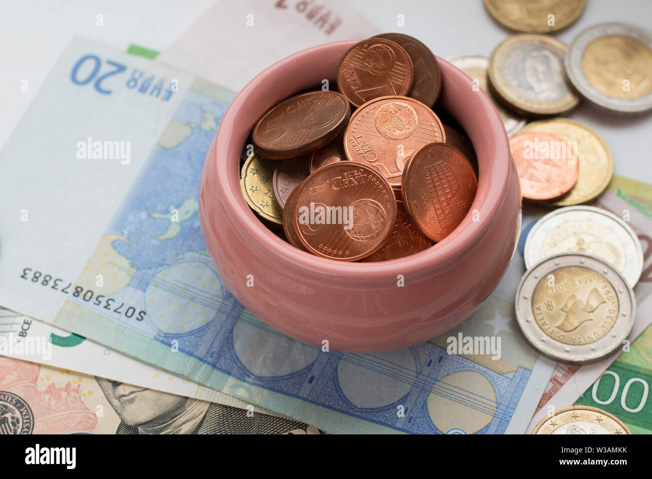 Cup con monete sulle banconote dello sfondo. Concetto del tesoro, simbolo di ricchezza e di abbondanza. Messa a fuoco selettiva Foto Stock