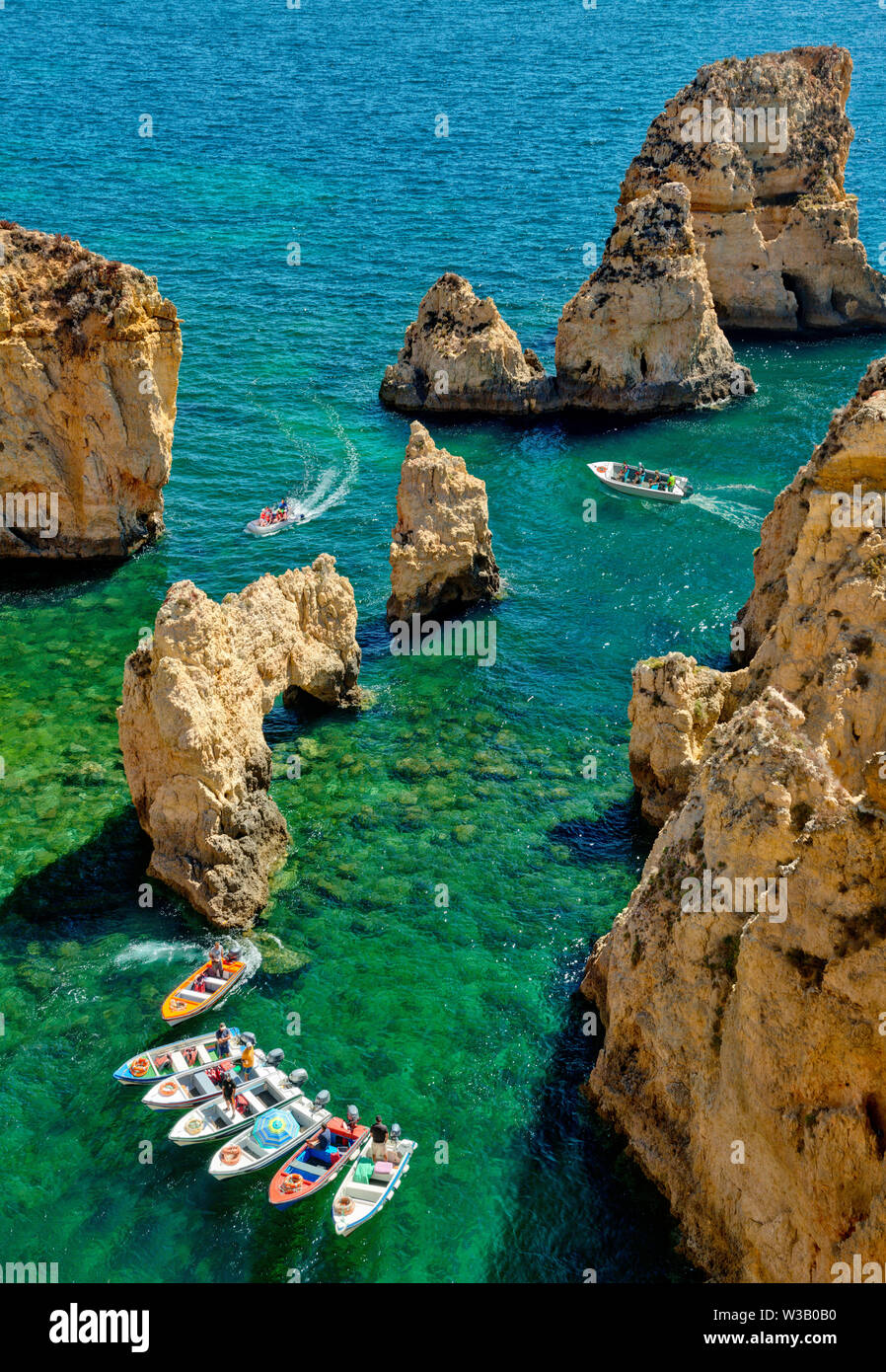 Ponta da Piedade, Lagos, Algarve, con barche da pesca in attesa di dare gite in barca Foto Stock