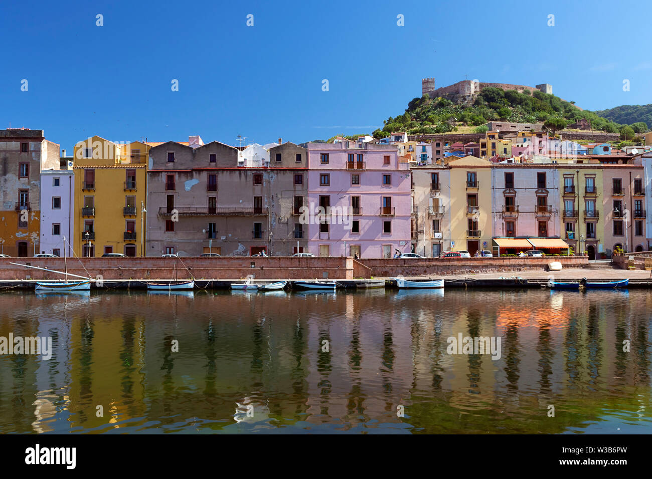 Vista di Bosa, Sardegna, con il vecchio colorate case italiane e il castello sulla collina. Fiume Temo in primo piano. Giorno di estate shot. Foto Stock