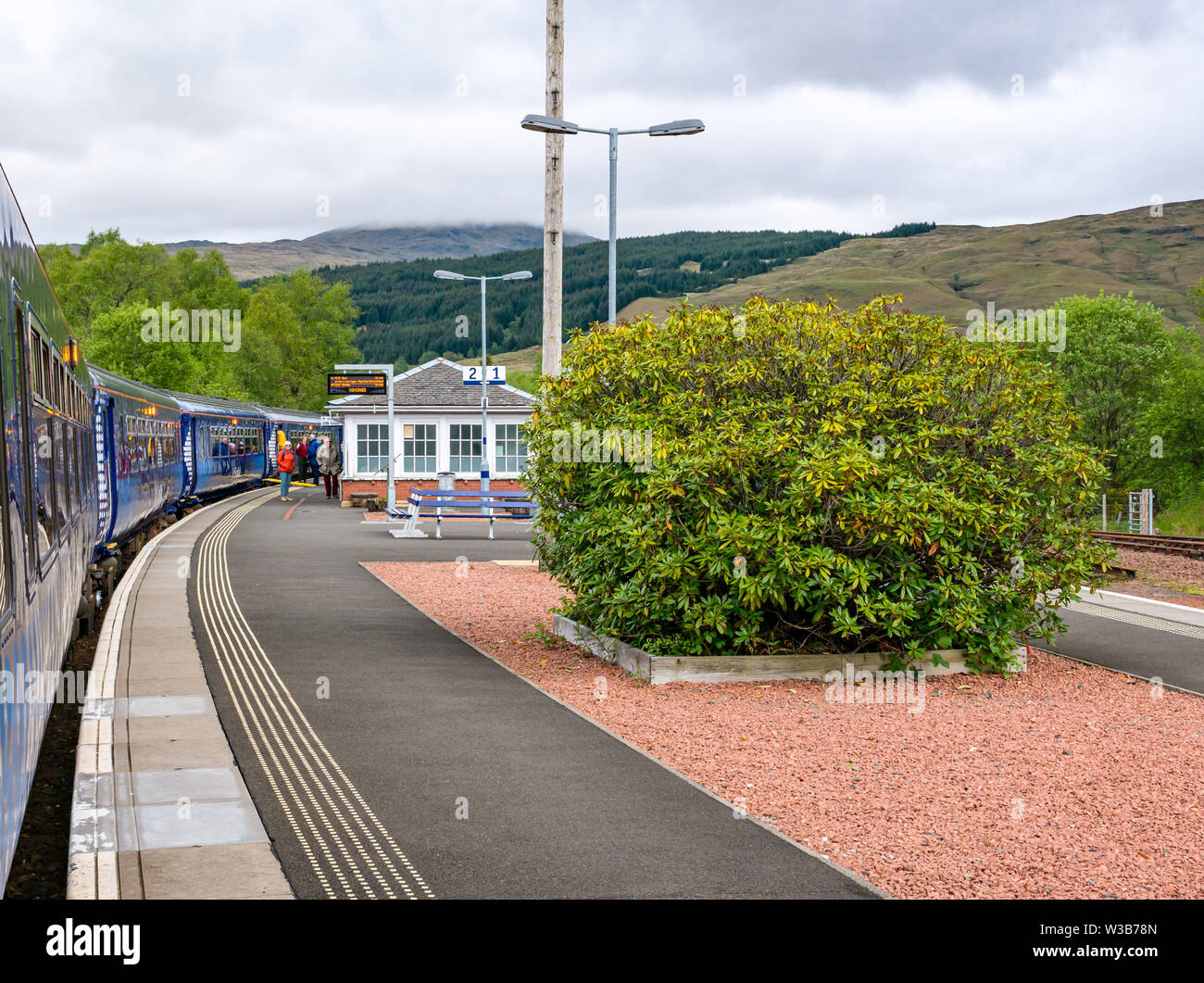 Crianlarich rural stazione ferroviaria piattaforma con treno ScotRail su West Highland linea ferroviaria, Stirlingshire, Scotland, Regno Unito Foto Stock