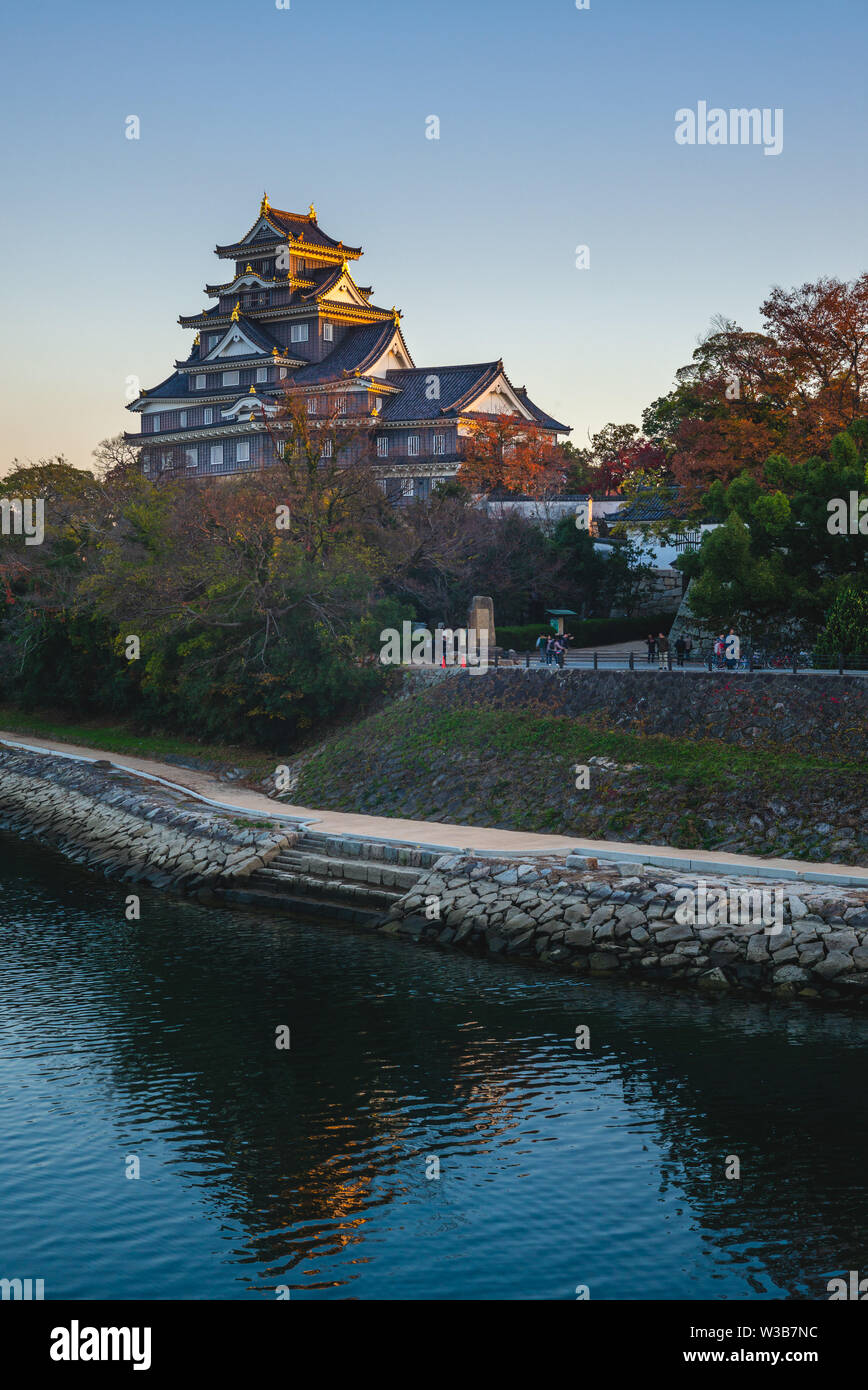 Castello di Okayama dal fiume asahi in Giappone al crepuscolo Foto Stock