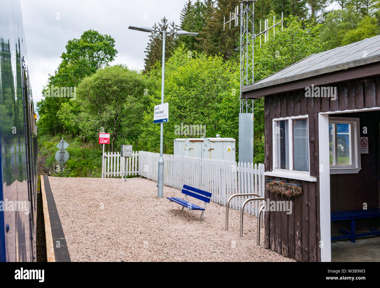 Loch Eil rural stazione ferroviaria piattaforma e nome sign con treno ScotRail su West Highland linea ferroviaria, Highlands scozzesi, Scotland, Regno Unito Foto Stock