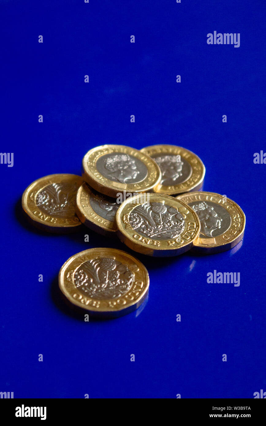 Una libbra di monete con sfondo blu Foto Stock
