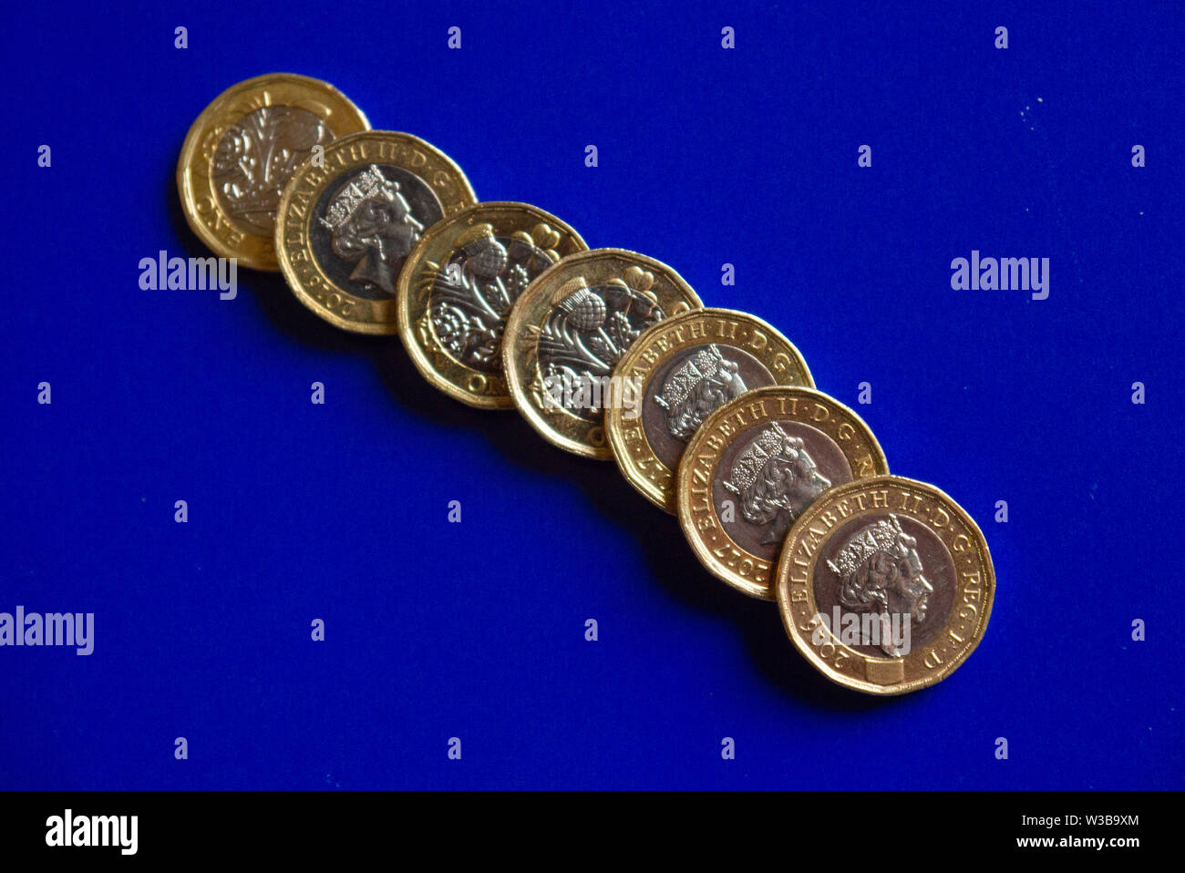 Una libbra di monete con sfondo blu Foto Stock