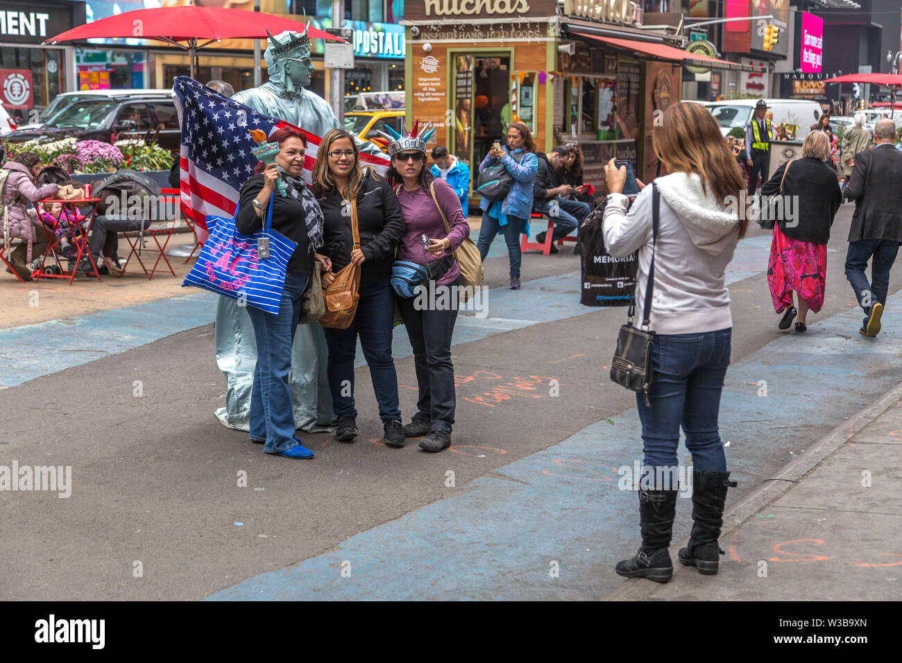 New York City, NY, Stati Uniti d'America - 16 Ottobre 2013: i turisti a piedi attorno a scattare foto e selfies nella zona di Times Square, Manhattan Foto Stock