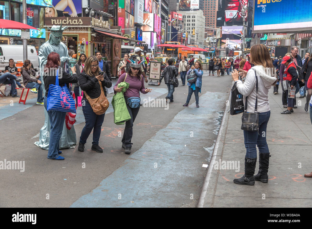 New York City, NY, Stati Uniti d'America - 16 Ottobre 2013: i turisti a piedi attorno a scattare foto e selfies nella zona di Times Square, Manhattan Foto Stock