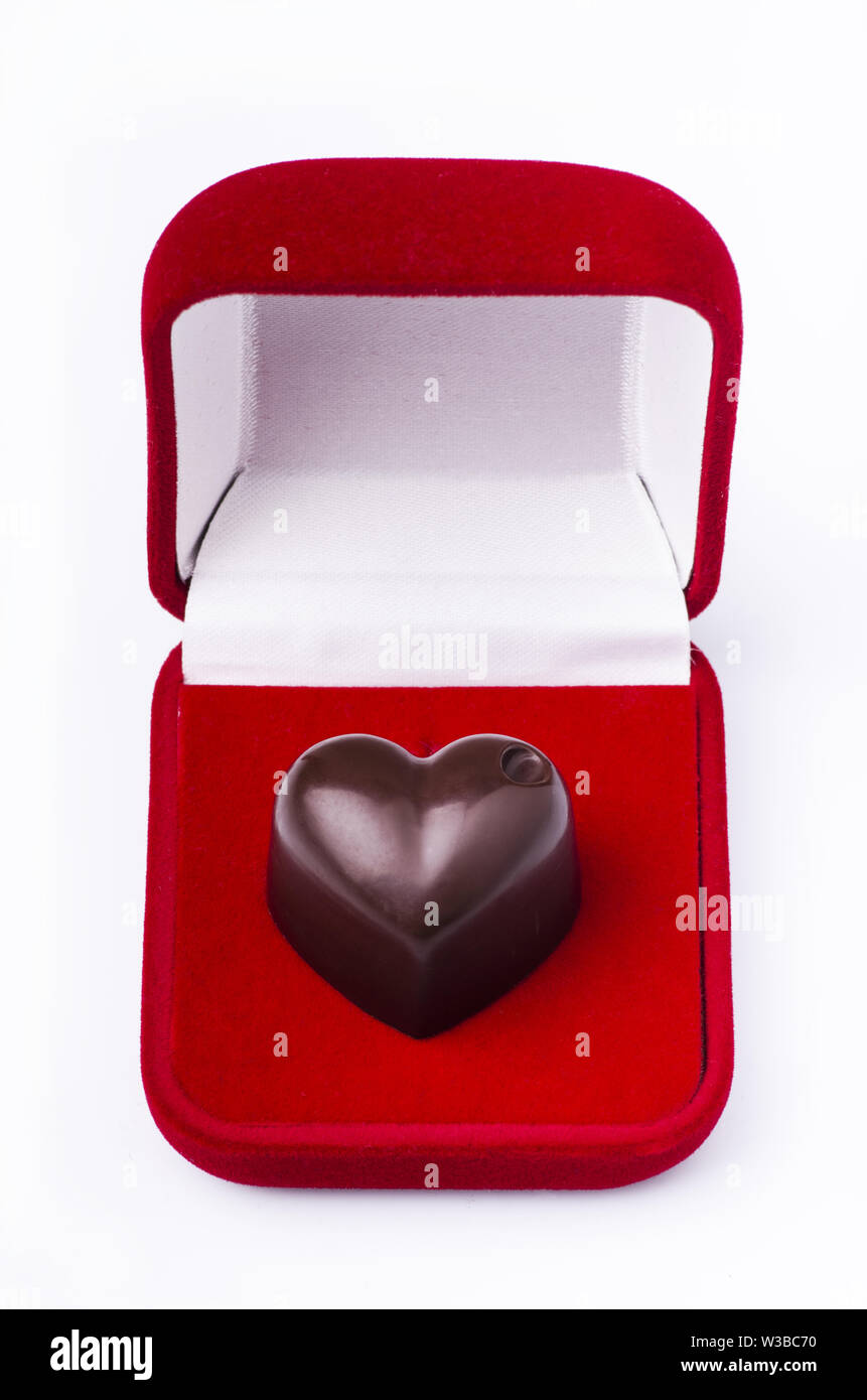 A forma di cuore il cioccolato in un velluto rosso box Foto Stock