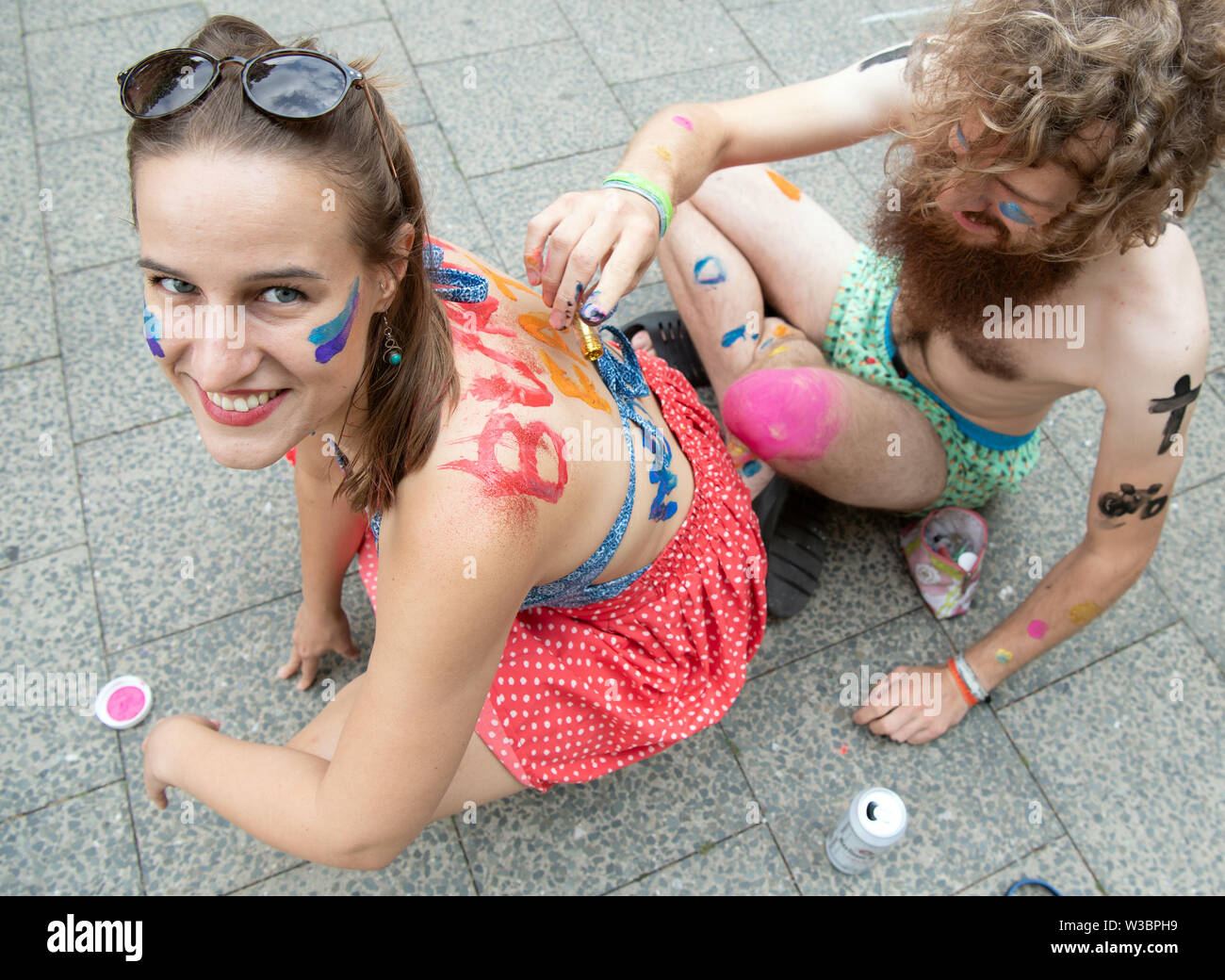 Berlino, Germania. 14 Luglio, 2019. Alisa e vernice Bjale stessi durante il bodypainting presso l'azione di protesta '2a Berlino Bikini- und Badehose bicicletta". I partecipanti hanno quindi dimostrato di pedalare sulla rotta da a Friedrichshain Kreuzberg per maggiore sicurezza nel traffico stradale, contro il corpo svergognare e la posizione dominante delle vetture in città. Credito: Soeren Stache/dpa/Alamy Live News Foto Stock