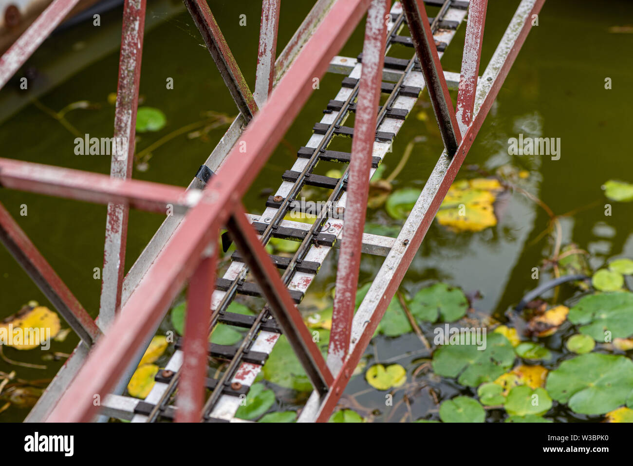 Ponte su un laghetto è il modello ferroviario in giardino in Burbage, Wiltshire, Regno Unito Foto Stock