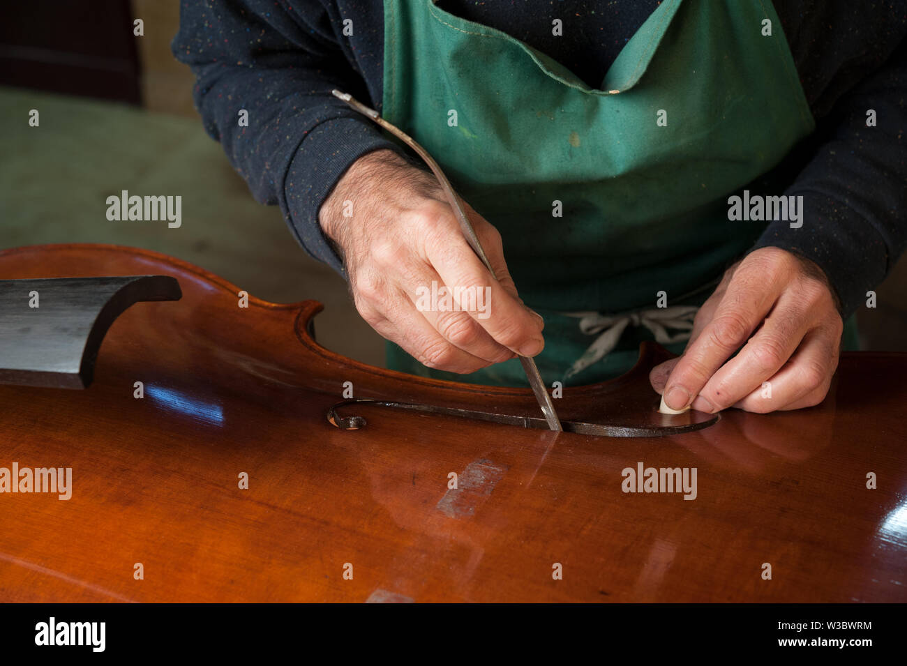 Il maestro liutaio costruisce un contrabbasso nel suo laboratorio Foto Stock