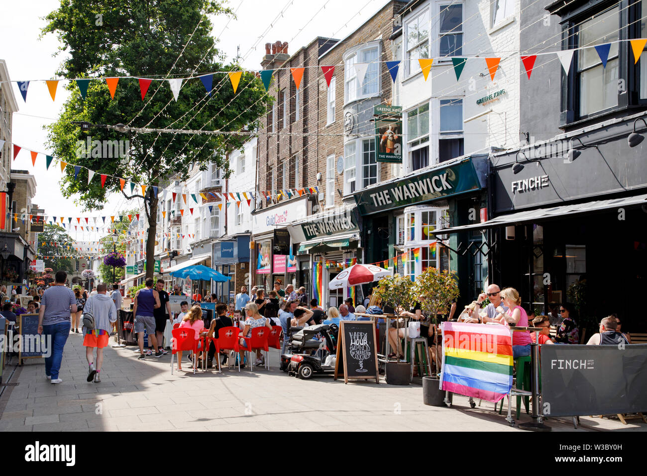 WORTHING, Regno Unito - 13 luglio 2019: le persone che si godono la giornata in giro per la città decorate per Gay Pride Parade Foto Stock