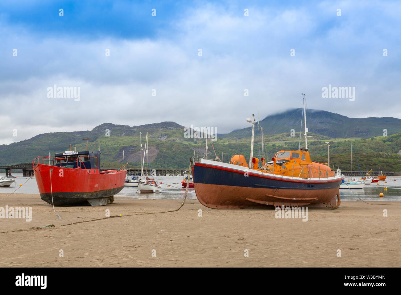 Un ex RNLI classe Watson scialuppa di salvataggio si siede sulla sabbia in acque basse nel Mawddach estuary a Blaenau Ffestiniog, Gwynedd, Wales, Regno Unito Foto Stock