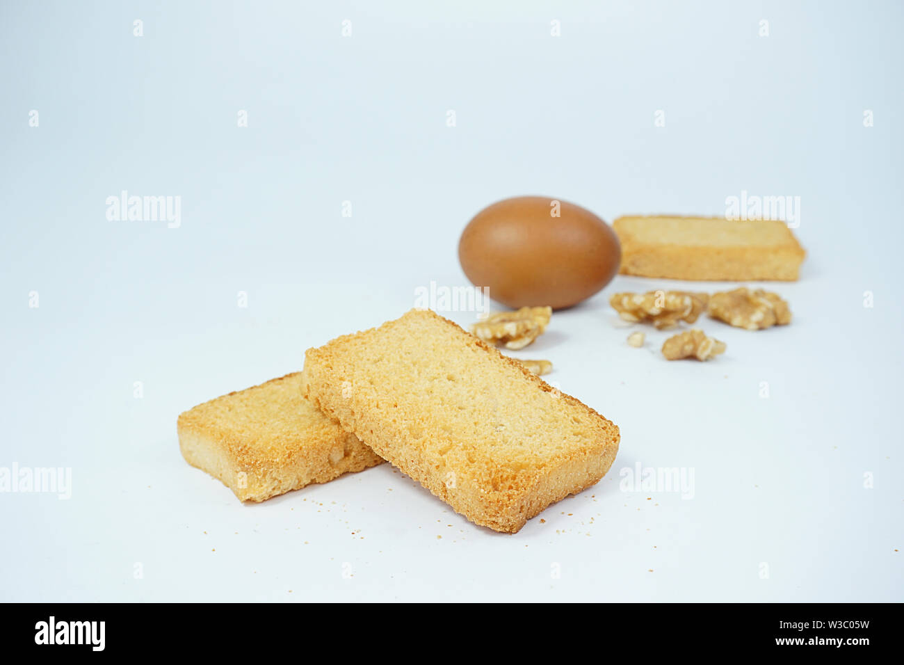 Fette biscottate di grano cuocere il matterello e cottura del pane ingrediente dadi spuntini uovo marrone isolati su sfondo bianco Foto Stock