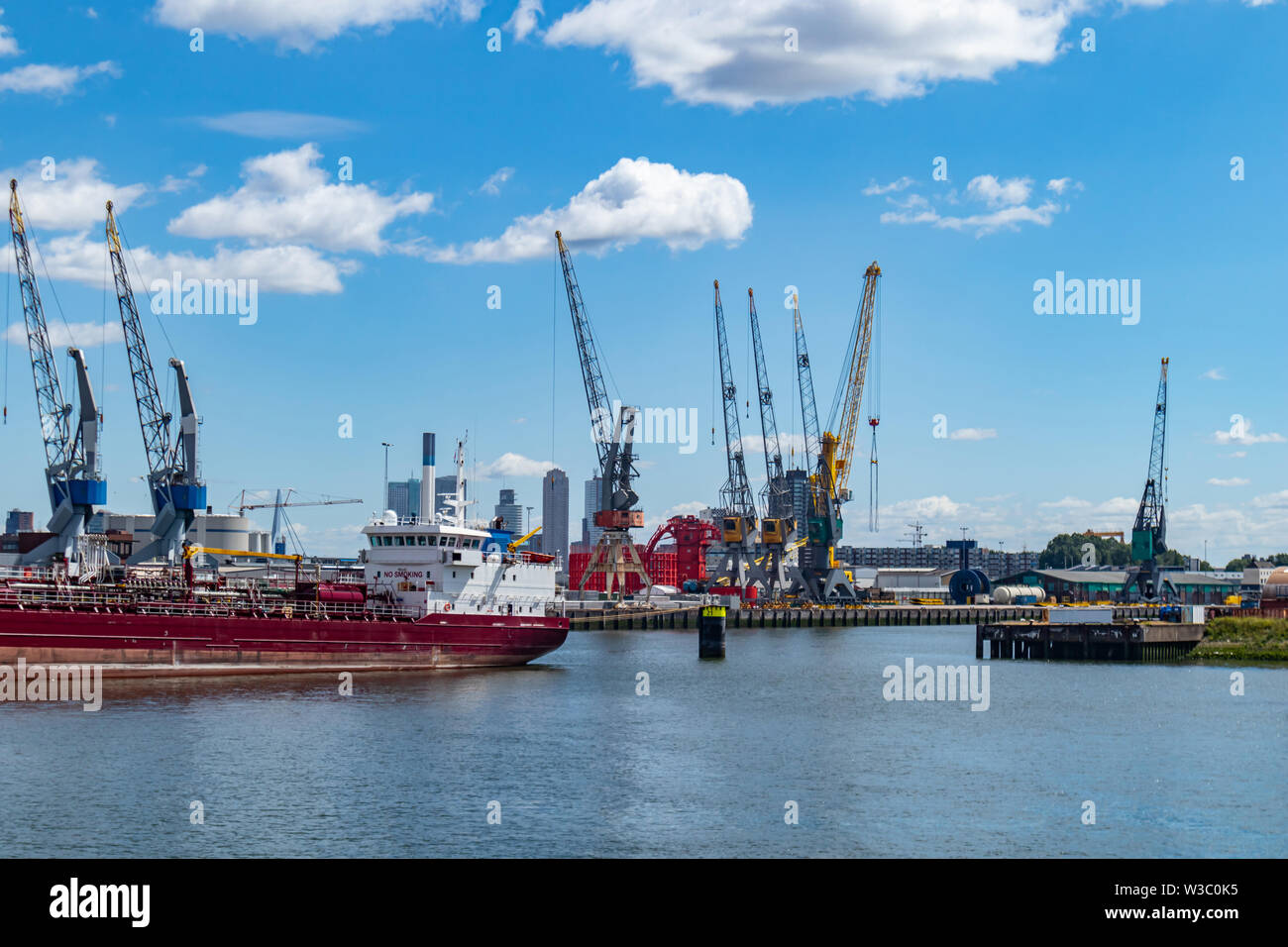 Logistica. Enormi gru e navi ancorate al porto. International porto commerciale, città di Rotterdam sfondo, soleggiata giornata estiva Foto Stock