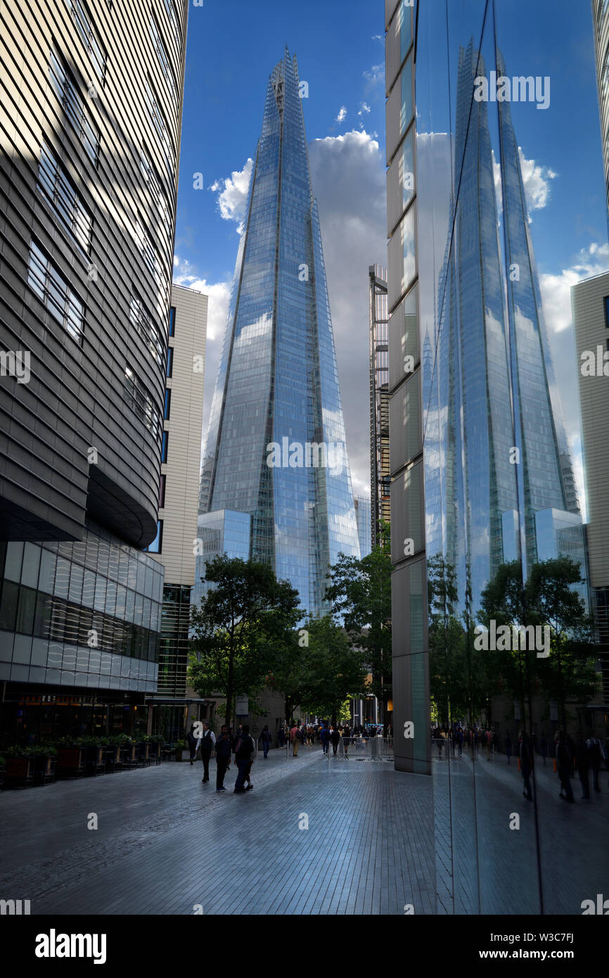 La riflessione del vetro guglia della Shard nel palazzo di vetro su più Londra Riverside pedonale London Inghilterra England Foto Stock
