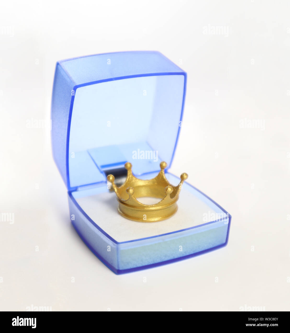 Corona d'oro in un blue translucent confezione regalo su sfondo bianco Foto Stock