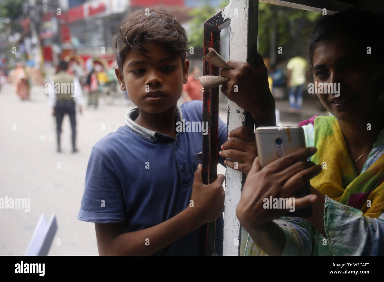 Luglio 15, 2019 - Dhaka, Bangladesh - Arif (13), un lavoratore di bambino in piedi dietro un leguna come lavora come un helper di Dhaka. Molti sotto età bambino opera nel settore dei trasporti nel paese. (Credito Immagine: © MD Mehedi Hasan/ZUMA filo) Foto Stock