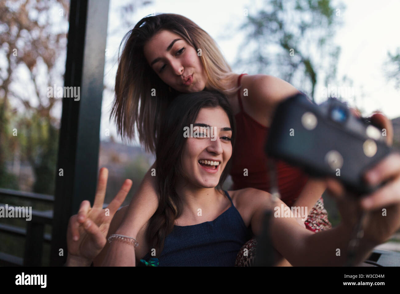 Due giovani donne prendere un selfie sul balcone la sera Foto Stock