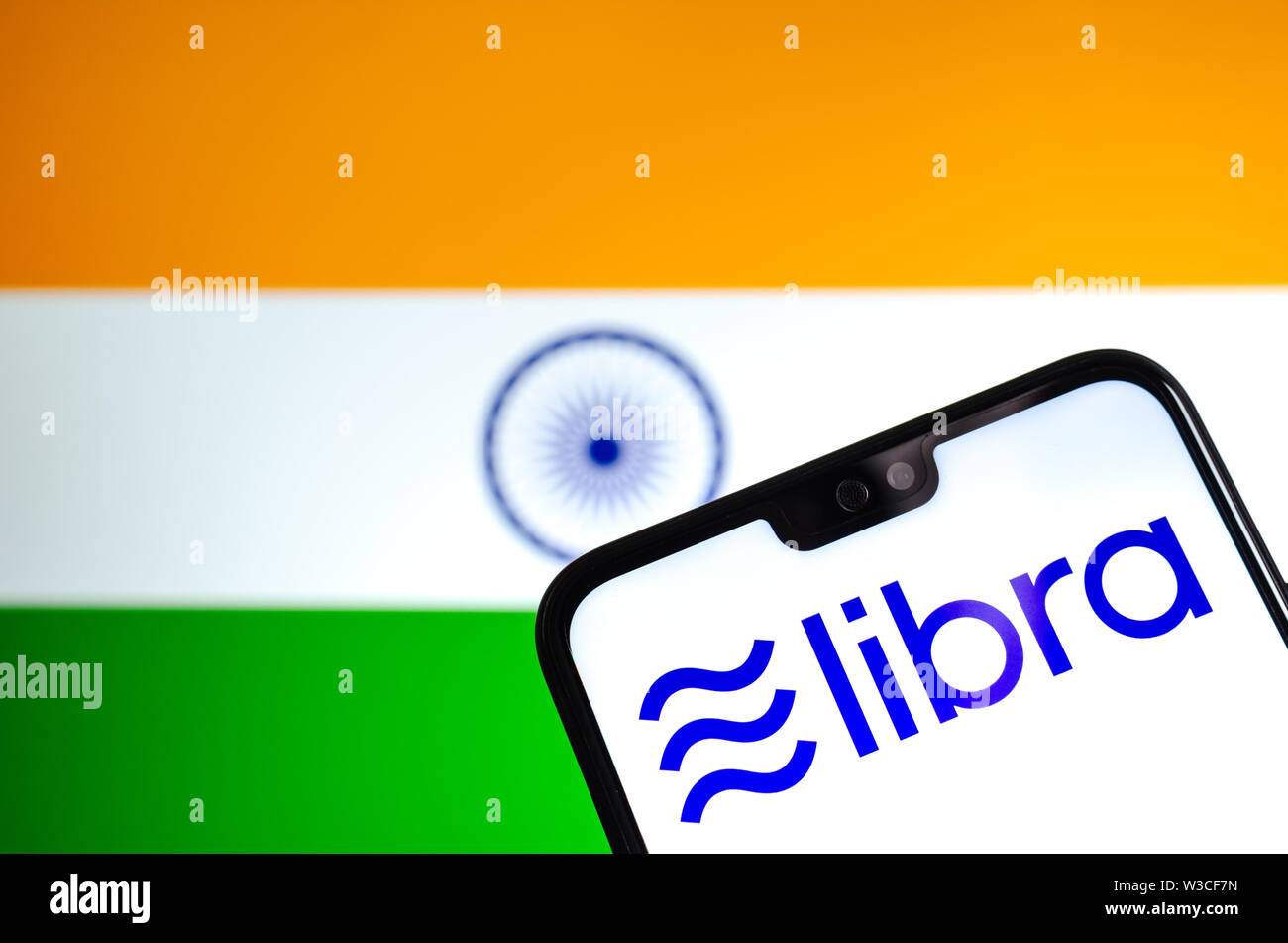 Facebook Libra crypto logo valuta sullo smartphone e sfocata bandiera dell India in una schermata di un laptop sullo sfondo. Foto concettuale. Foto Stock